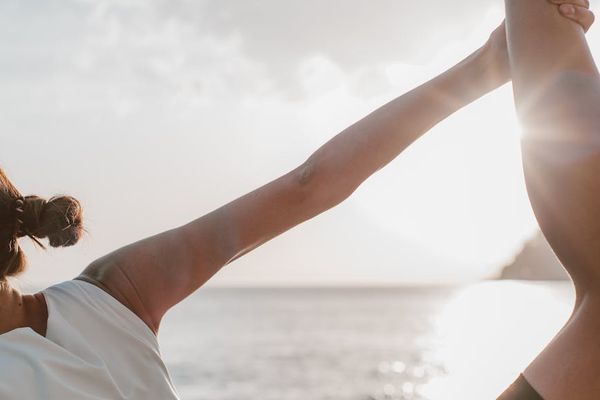 Woman in a peaceful meditation pose during sunset.