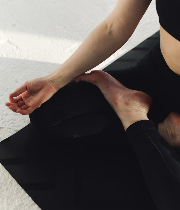 Woman meditating in a graceful yoga pose on a serene mat.